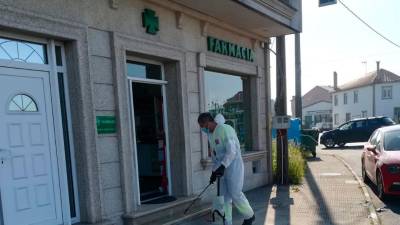 Desinfectan en Vimianzo o exterior dunha farmacia