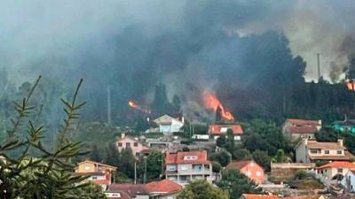 Imagen de las llamas cercanas a las casas en el incendio de Moaña, este lunes por la tarde. Foto: Incendios de Galicia.
