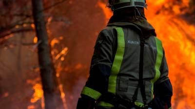 GRAF9824. TOÉN (OURENSE), 07/08/2020.- Un bombero realiza labores de extinción en el incendio forestal que permanece activo en el municipio orensano de Toén. EFE/Brais Lorenzo