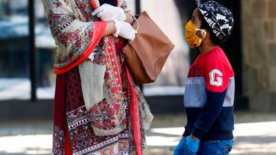 BARCELONA, 28/04/2020.- Una mujer musulmana pasea con su hijo por Ciutat Vella este martes, cuando se cumplen 45 días de confinamiento por el estado de alarma decretado por el Gobierno por la crisis del coronavirus. EFE/Quique García