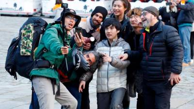 Un grupo de peregrinos, entre ellos varios coreanos, se sacan una fotografía en el Obradoiro. Foto: A. Hernández