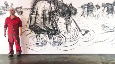 o mural. O artista Ramón Trigo ante o mural de catro metros que realizou en 2020 cando remataron as obras de construción do Museo do Mar de Noia e no que pintou unha escena de marisqueo. Foto: Suso Souto