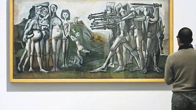 Un hombre observa la obra ‘Masacre en Corea’, del artista español Pablo Picasso.