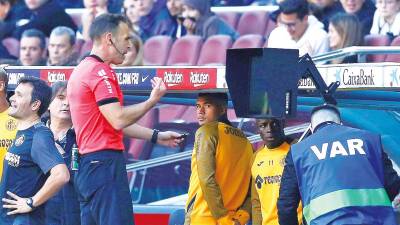 El árbitro Guillermo Cuadra Fernández consulta el VAR durante el partido entre el Fútbol Club Barcelona y el Getafe Club de Fútbol. Foto: Enric Fontcuberta. 