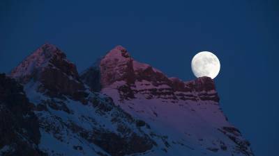 Superluna pintada sobre las montañas. Gryon, Suiza. (Autor, Anthony Anex para EFE).