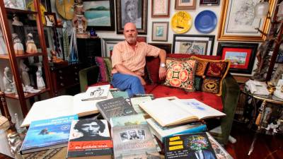 Ángel Patricio en su casa de la capital lucense con algunos de los libros dedicados de su colección Foto: ECG