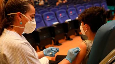 vacunación. Una sanitaria procediendo a vacunar un menor contra la covid. Foto: Isabel Infantes - Europa Press