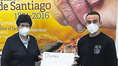 Sor Alicia con el cheque que le entregó Víctor Ocampo, del Gelmírez