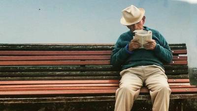 Pensionista leyendo en una calle de Compostela FOTO: ladiapo.com