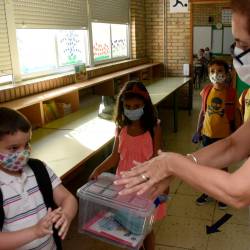 Unha docente galega ensina aos seus pequenos alumnos a frotar as mans co xel hidroalcólico.