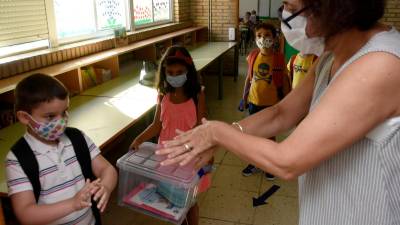 Unha docente galega ensina aos seus pequenos alumnos a frotar as mans co xel hidroalcólico.