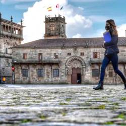 Una universitaria cruza la Praza do Obradoiro, con el Pazo de San Xerome al fondo. Foto: Santi Alvite