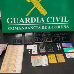 Teléfonos, tarjetas y dinero en efectivo incautado al grupo criminal desactivado en Carballo. Foto: Guardia Civil