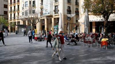Personas paseando con mascarilla en calles adornadas listas para la Navidad. Foto: E.P.