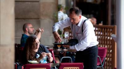 trabajo. Un camarero recogiendo mesas en un restaurante. Foto: Europa Press