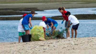 POR TIERRA. Un grupo de jóvenes retirando residuos en una playa en el marco del proyecto Mares Circulares. Foto: Mares Circulares