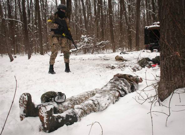 Un voluntario de las Fuerzas de Defensa Territorial de Ucrania mira el cadáver de un soldado en un bosque en las afueras de <a rel="nofollow" href="https://es.wikipedia.org/wiki/J%C3%A1rkov" target="_blank">Kharkiv</a>. (Fuente, www.nationalgeographic.com.es/fotografia)