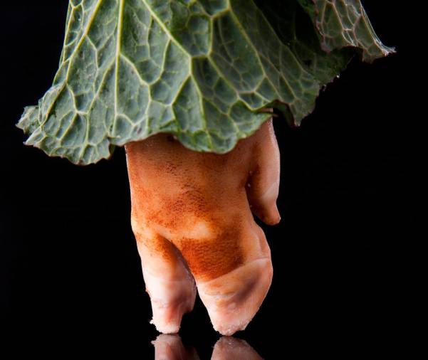 Foto de un grelo rodeando la pezuña de una pata de cerdo simulando una falda. FOTO: www.ladiapo.com