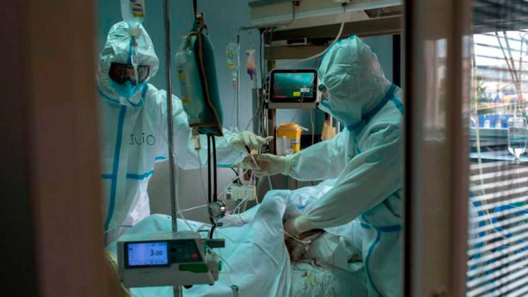 Trabajadores sanitarios atienden a un paciente con coronavirus en la uci del Hospital Cosaga de Ourense. Foto: Brais Lorenzo / Efe