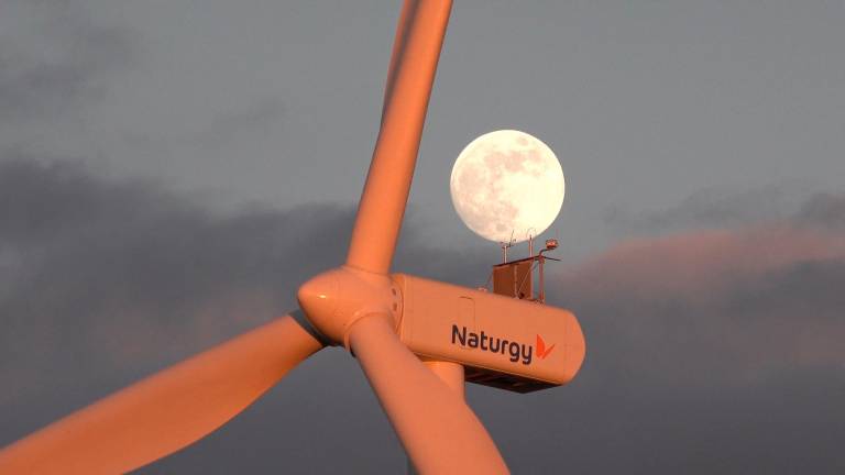 Vista de un aerogenerador de Naturgy con la luna al fondo