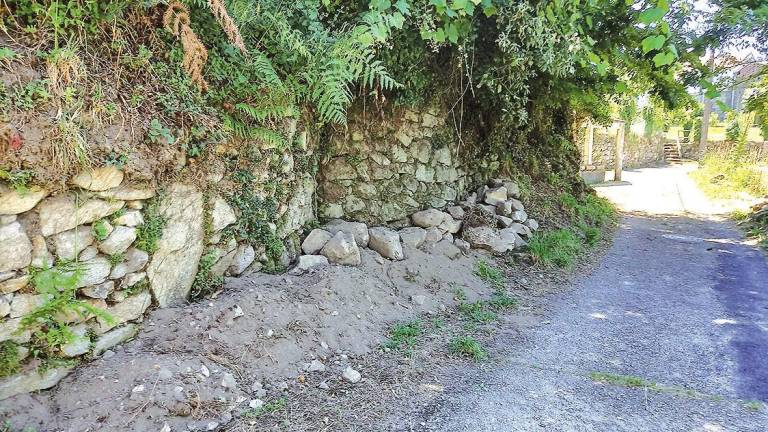 Muro de pedra xunto o camiño de acceso ás casas . Foto: G.