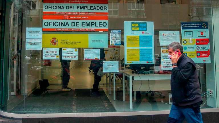 Imagen de archivo de una persona pasando por delante de una oficina de empleo. Foto: Ricardo Rubio / E.P.