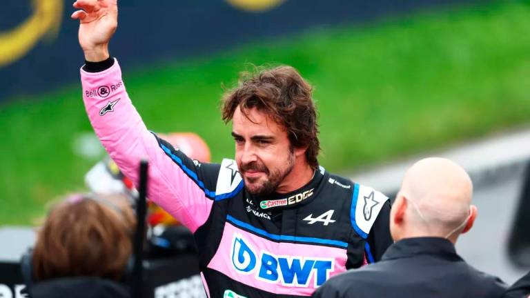 El piloto Fernando Alonso saluda a los aficionados
