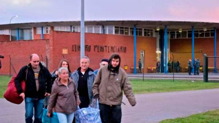 TEIXEIRO. Domingo Troitiño, justo en el centro, tras dos familiares que llevan una bolsa con sus pertenencias el día que abandonaba la cárcel de Teixeiro. Foto: archivo ECG