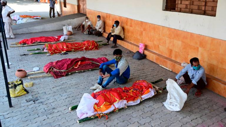 pandemia. Varias personas esperan al lado de los cadáveres de sus familiares, fallecidos de COVID-19, a su turno para incinerar el cuerpo en un crematorio de Prayagraj, en India. Foto: autorfo Efe