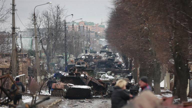 La gente mira los restos de varios vehículos militares rusos en una carretera en la ciudad de <a rel="nofollow" href="https://es.wikipedia.org/wiki/Bucha" target="_blank">Bucha</a>. (Fuente, www.nationalgeographic.com.es/fotografia)