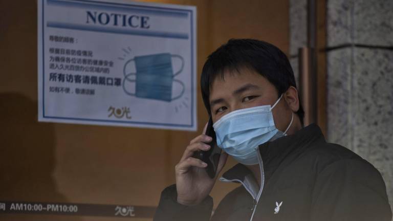 Un hombre con mascarilla habla por teléfono en Shanghái (China), el 10 de enero. EFE/EPA/ALEX PLAVEVSKI