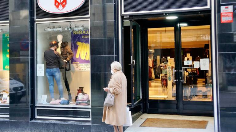 Una mujer pasa por delante de una tienda de moda en Santiago . Foto: F. B. 
