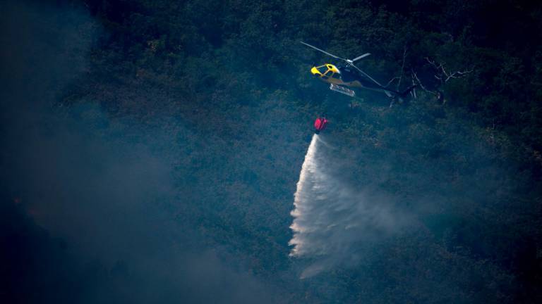 Un helicóptero lanzando una carga de agua sobre los montes de Lobios. Foto: Brais Lorenzo