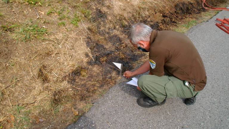 Un agente analizando el lugar en el que se encontró la colilla. Foto: Xunta
