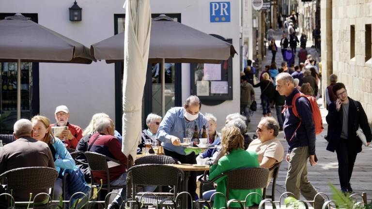 Un camarero atiende una mesa en la terraza del restaurante ‘Casa Barbantes’, en la rúa do Franco, en Santiago FOTO: Fernando Blanco