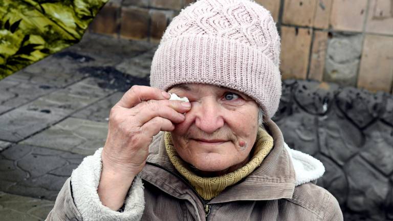 21 de abril de 2022, Ucrania, Makariv: Tetiana Koronik, de setenta años, que vende leche y queso frente a un edificio destruido en la plaza Makariv, se limpia una lágrima. Foto: Jussi Nukari/Lehtikuva/dpa 21/04/2022