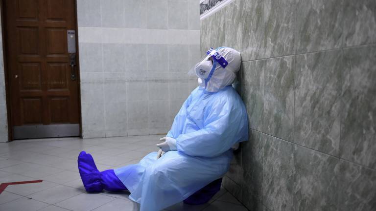 Un trabajador sanitario descansa tras horas de duro trabajo atendiendo a enfermos de coronavirus en un hospital de Malasia Foto: Zulaikha Zainuzman/Bernama