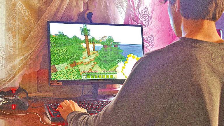 Un jugador usando su ordenador para jugar a la serie de videojuegos Minecraft. Foto: Alex. K