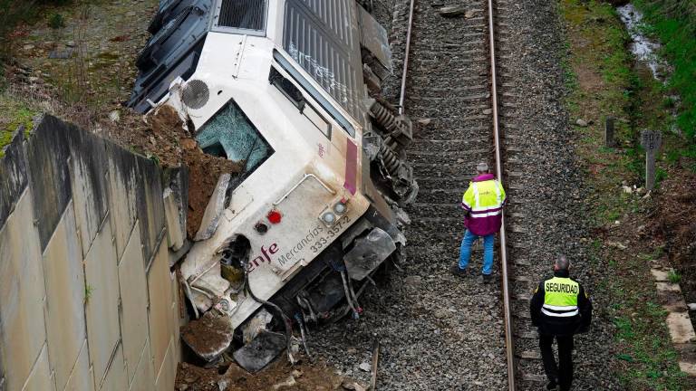 Dos hombres realizan las labores de retirada del tren accidentado, a 24 de enero de 2023, en A Xesta, Lalín, Pontevedra (España). - Álvaro Ballesteros - Europa Press