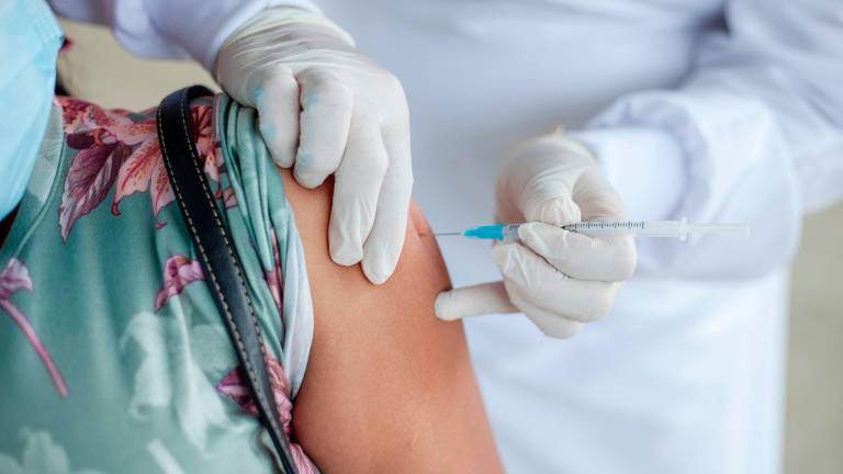 Un personal sanitario inoculando una vacuna contra el coronavirus en el brazo de una paciente. Foto: ECG