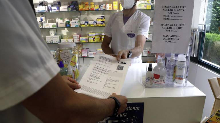 Un farmacéutico de Santiago muestra un certificado covid FOTO: A. Hernández