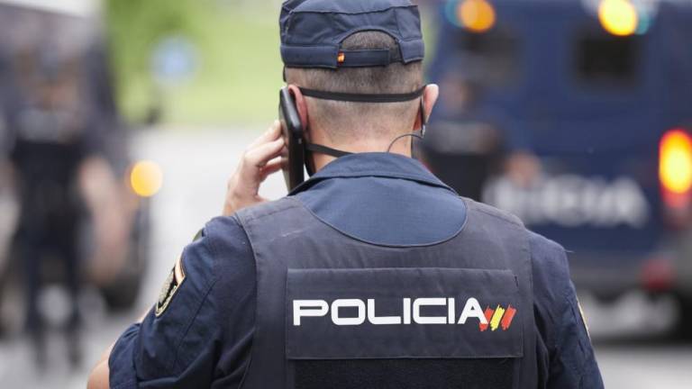 En la foto de archivo, un agente de la Policía Nacional hablando por teléfono. EUROPA PRESS