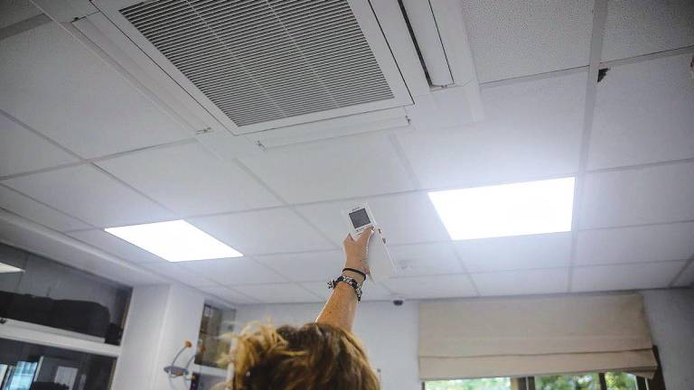 Una mujer regula la temperatura del aire acondicionado de la oficina. Foto: Ricardo Rubio/E.P.