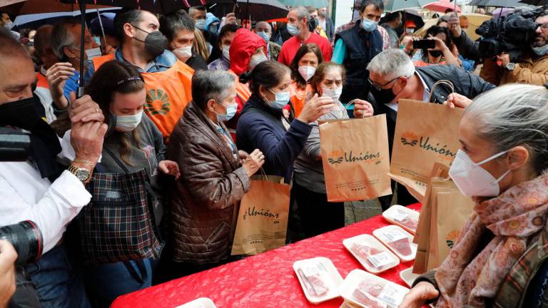 Ganaderos convocados por el sindicato Unións Agrarias repartiendo de forma gratuita este viernes en Santiago de Compostela más de 1.000 kilos de carne para protestar contra los bajos precios que reciben // Fotos: ANTONIO HERNANDEZ