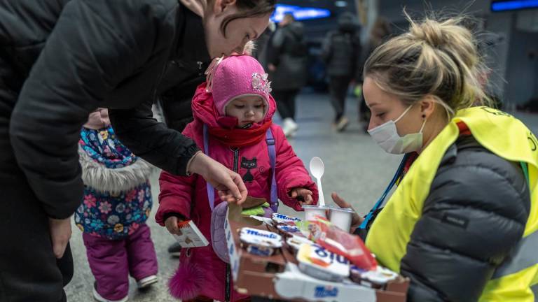 Decenas de refugiados procedentes de Ucrania esperan en la estación de tren de Cracovia, Polonia, mientras grupos de voluntarios reparten comida y bebida. EFE