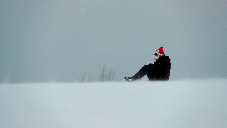 Un hombre con gorro navideño disfruta de la nieve caída ayer en la localidad lucense de Pedrafita. Foto: Eliseo Trigo/Efe