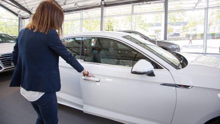 En la foto de archivo, una mujer abre un coche en un concesionario. IÑAKI BERASALUCE/EUROPA PRESS