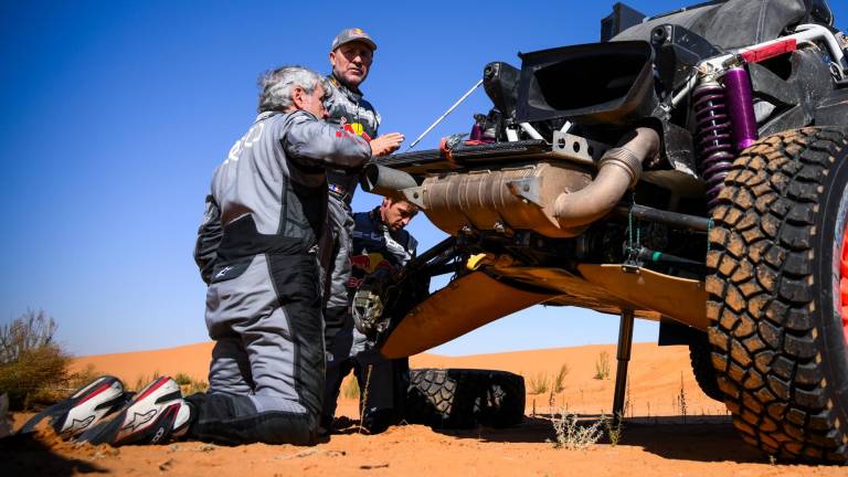AVERÍA Carlos Sainz, intentando reparar su vehículo ayudado por Peterhansel. Foto: AFP7