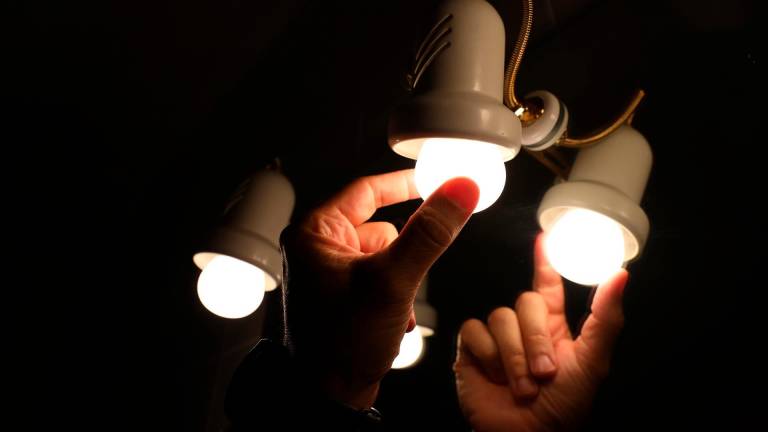 Una persona cambia la bombilla de una lámpara. FOTO: Marta Fernández
