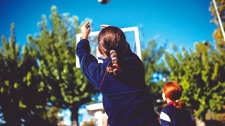 Dos niñas juegan al baloncesto en el patio de un centro educativo. Foto: Alejandro Martínez Vélez/E.P.